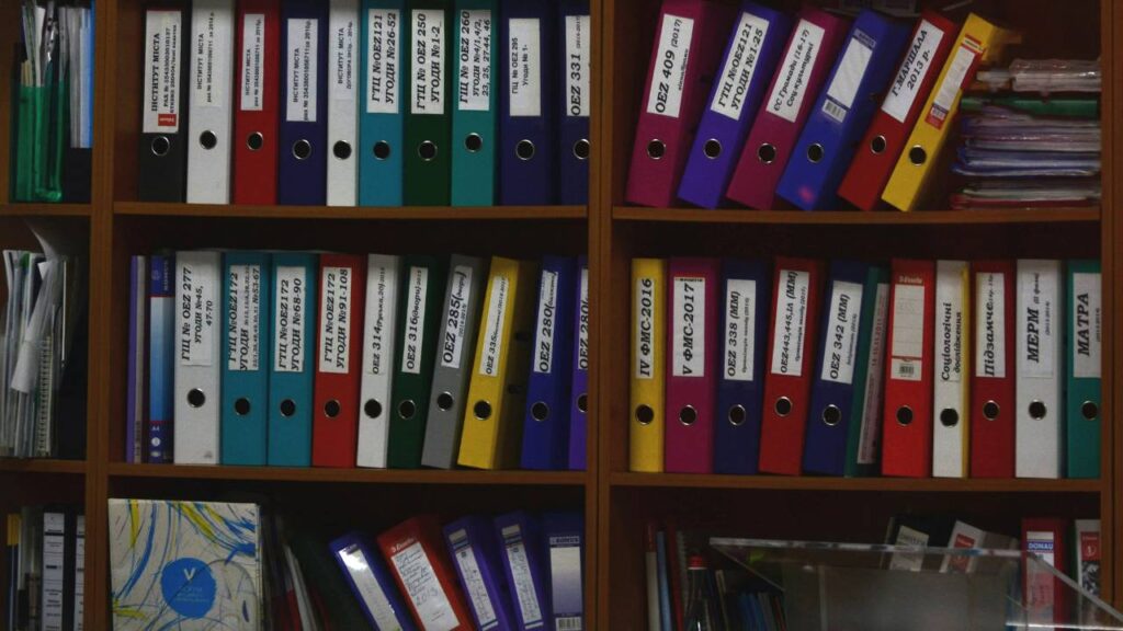 Wooden shelves full of folders containing documents