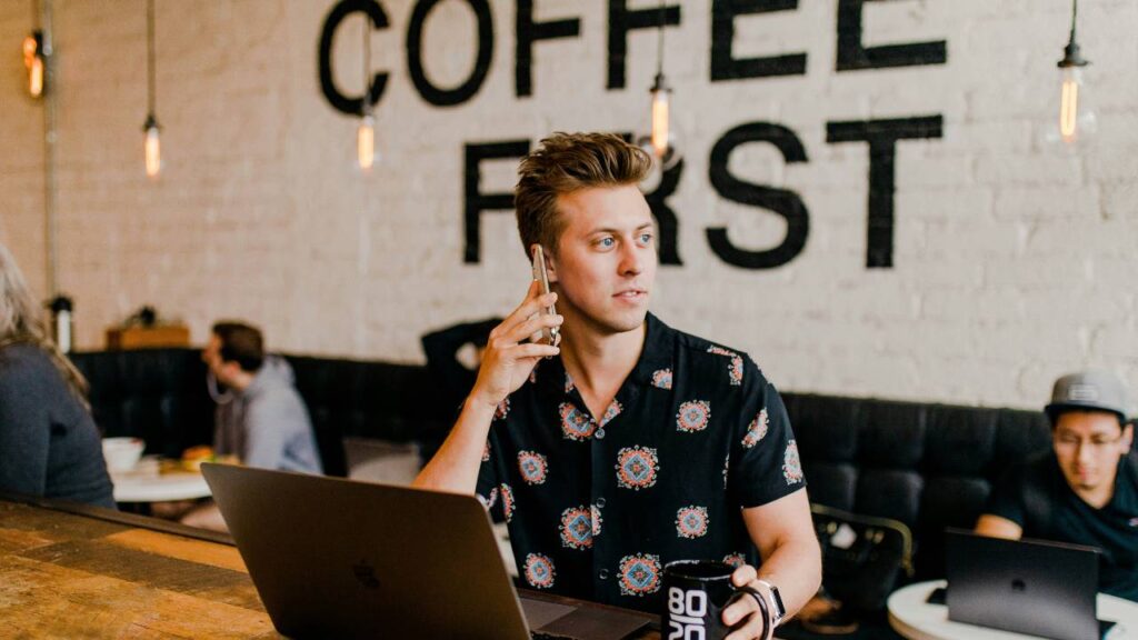 A young man using his smartphone in a coffee shop