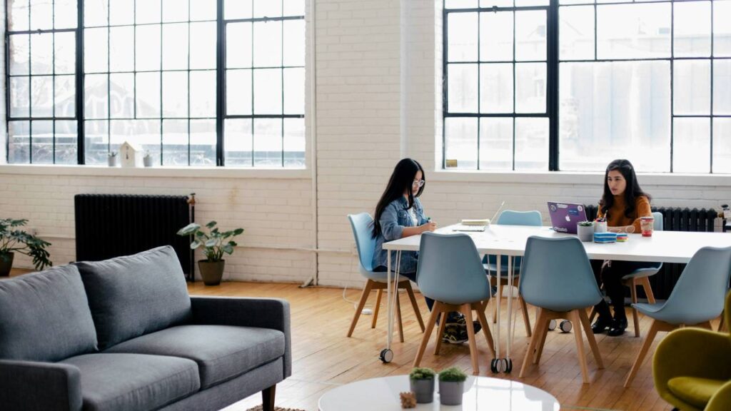 Two women sitting in a contemporary office with modern furniture