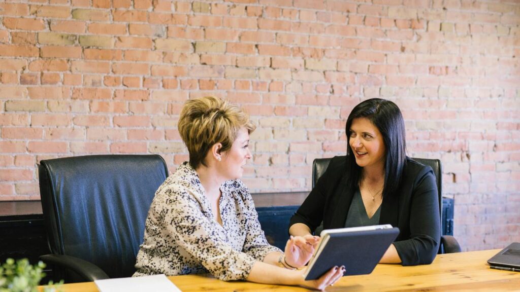 Two female employees talking in an office setting