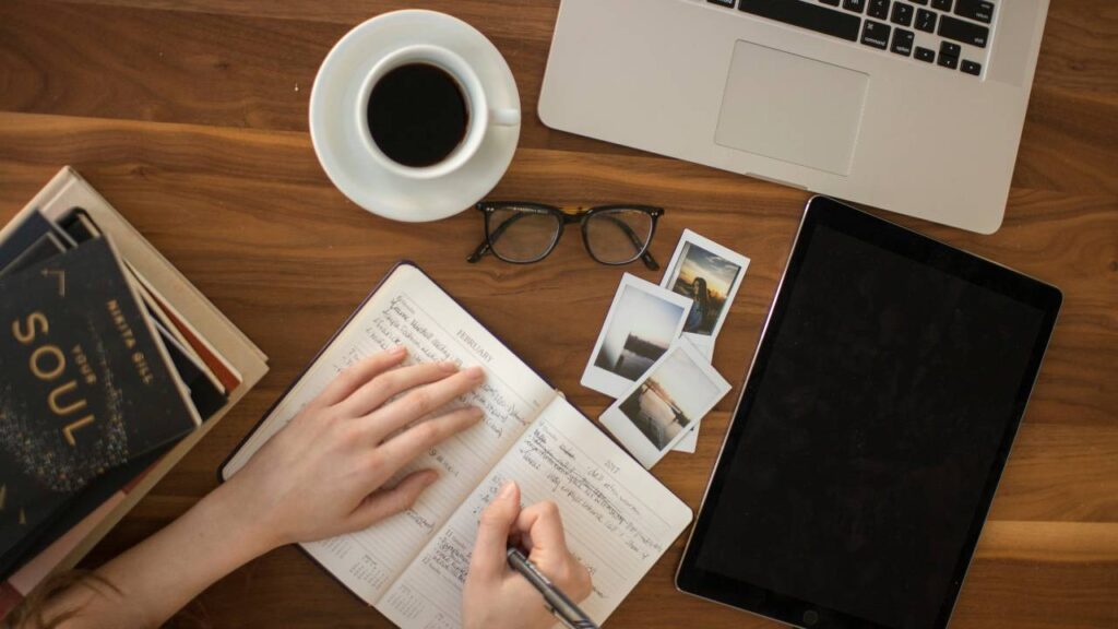 A woman using a pen to write in her notebook