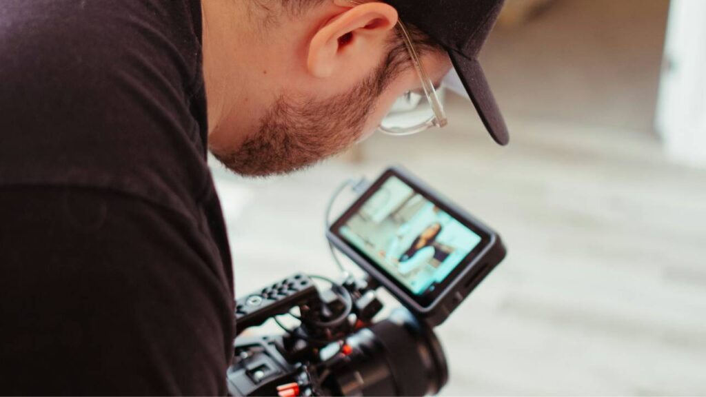 A man using a camera to film a female employee for an internal company culture video