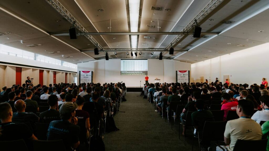 A hall full of people listening to a business event speaker 