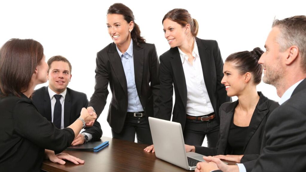 Several office employees greeting a new team member 