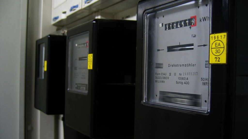 Three electricity meters mounted on a wall 