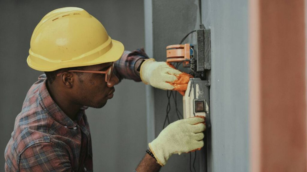 A man wearing a safety helmet checking electrical installations 